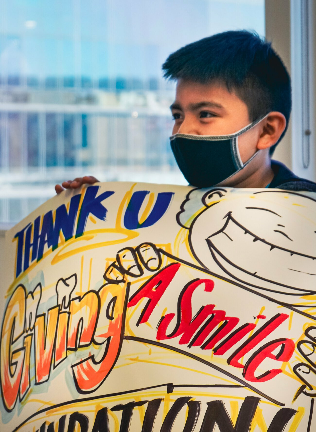 Beverly Hills Cosmetic Dentistry child patient holding a thank you sign